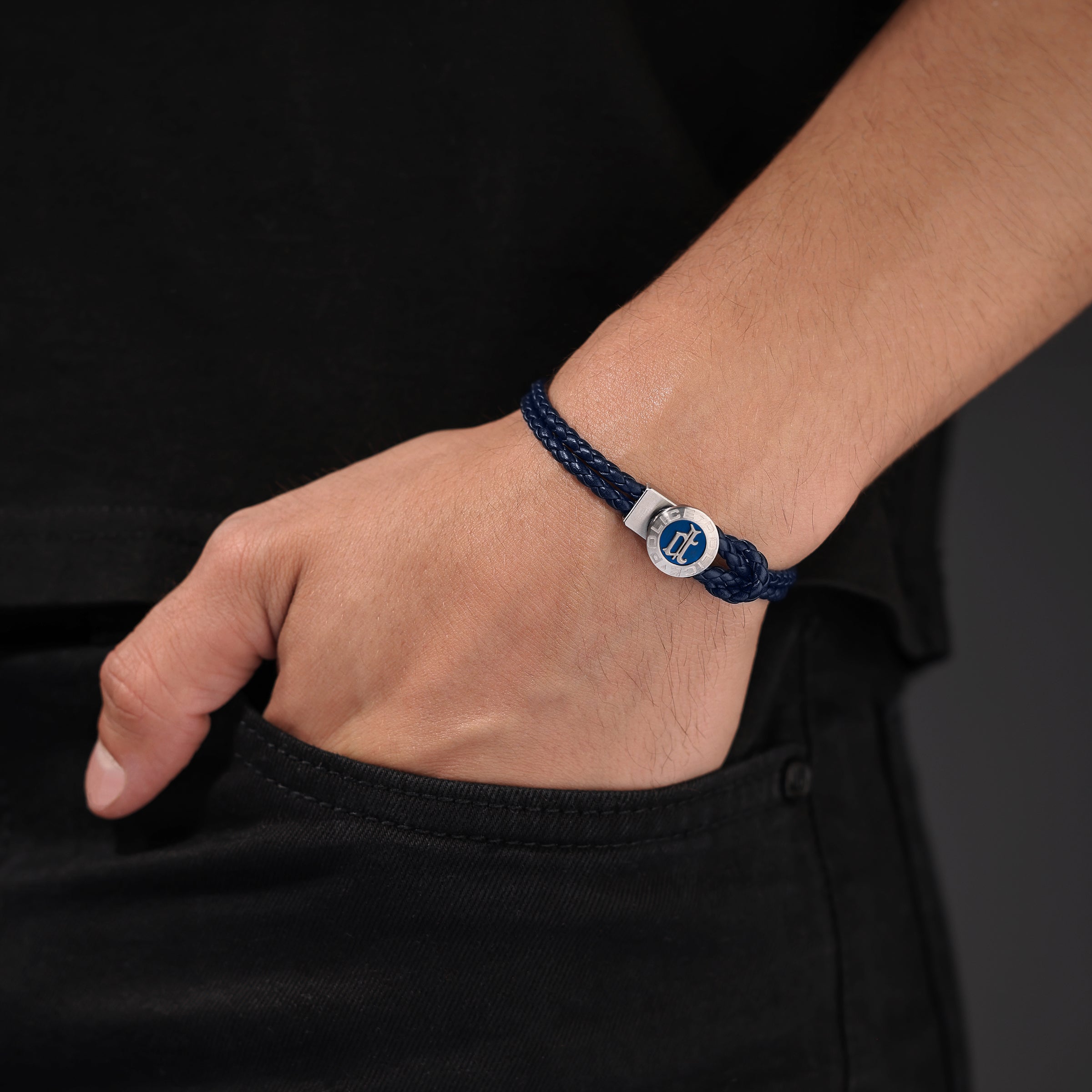 Dark blue braided leather loop bracelet with a silver-toned clasp featuring a circular blue enamel center and a silver-toned