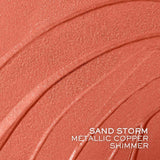 Swatch of Lancome Idole Tint in Sand Storm, a metallic copper shimmer with a textured finish.