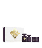 Initio Parfums Privés Atomic Rose fragrance ritual set including a 90ml Eau de Parfum, a hair perfume, and a 200ml body cream, standing beside a white textured presentation box with a bold gold graphic emblem, from blue salon.