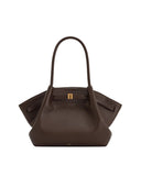 Dark brown pebbled faux leather tote bag with two top handles, a gold-toned rectangular buckle on the front strap, and winged