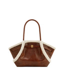 Brown leather tote bag with a single top handle, off-white plush trim, and a gold-toned rectangular clasp on the front.