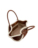 Brown leather tote bag with cream shearling trim, two brown handles, light beige interior, and a gold-toned magnetic snap.