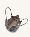 Grey pebbled leather tote bag with two top handles, white stitching, gold-toned magnetic snap, and light tan interior with a