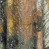 Sheer fabric with silver-toned sequins forming wavy lines and small flower clusters over an abstract underlayer in yellow, or