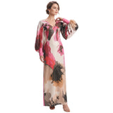 Pink, black, and beige abstract print maxi dress with V-neckline and long balloon sleeves with pink cuffs.