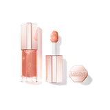 Clear lip gloss tube with peachy-pink liquid, rose gold-toned faceted cap. White applicator with peachy-pink tip. Detached ma