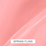Light coral pink lip gloss with a smooth, glossy finish and subtle light reflections.