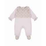 Front view of a Jules & Juliette Paris pink babygrow for infants, featuring a pink floral print chest panel, a ruffled collar, and floral-patterned feet.