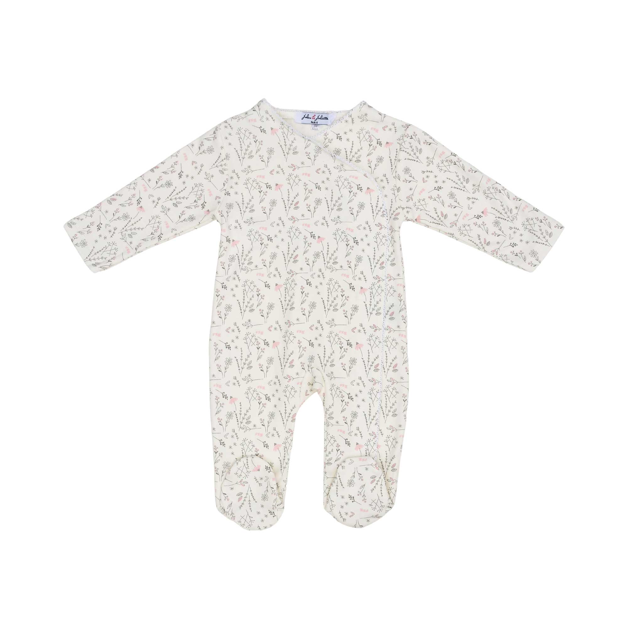 Front view of a Jules & Juliette Paris baby sleepsuit in cream with a pink botanical print and an asymmetrical wrap-front closure.