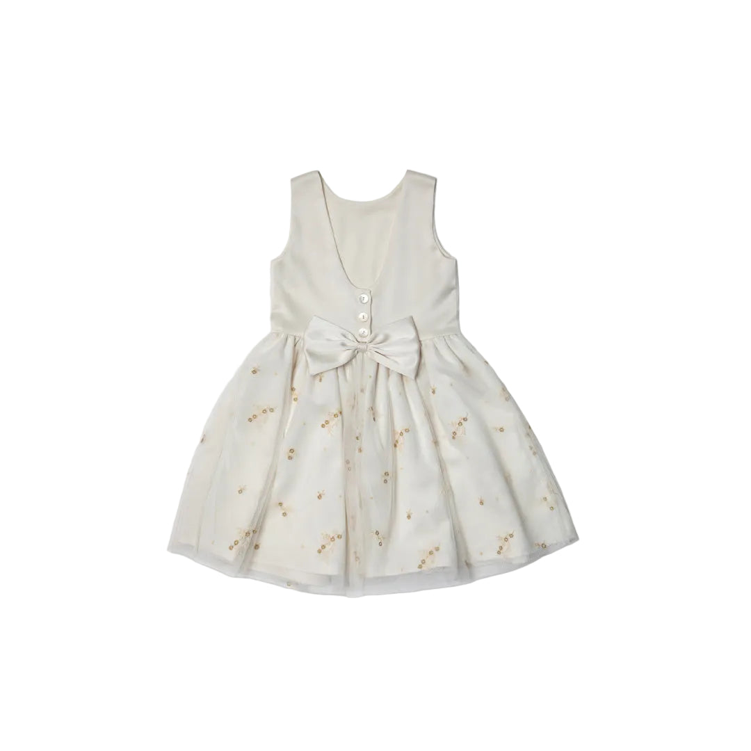 The back of the Jules & Juliette Paris ivory dress showing a deep V-neckline, three central buttons, and a large ivory satin bow above a gathered tulle skirt.