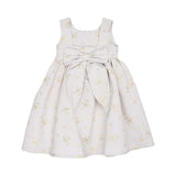 Back view of the Jules & Juliette Paris gold floral dress highlighting the large decorative bow at the waist and the square back neckline.