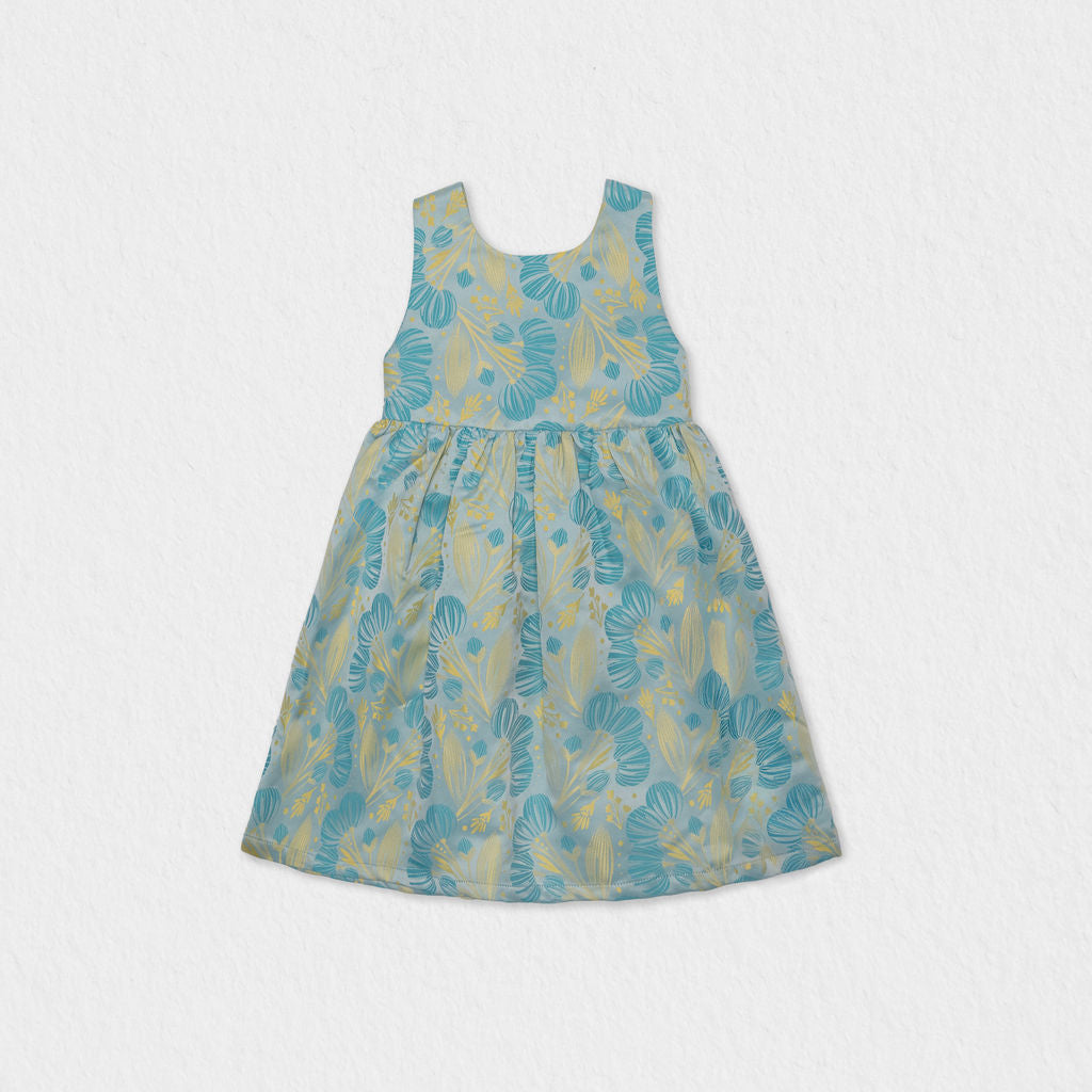 Front view of a Jules & Juliette Paris girls' sleeveless off-white jacquard dress featuring a metallic green pattern and a gathered skirt.