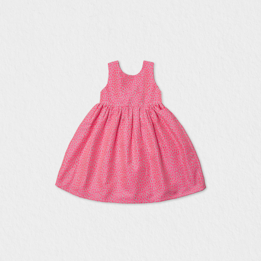 Front view of a Jules & Juliette Paris girls' sleeveless off-white jacquard dress featuring a metallic pink pattern and a gathered skirt.