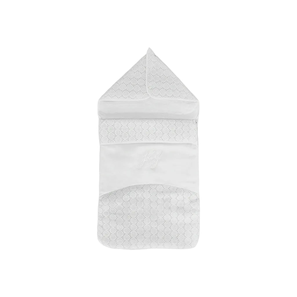 A white padded baby nest by Jules & Juliette Paris featuring lace floral embroidery, a pointed hood, and an embroidered "J&J" monogram on the front.