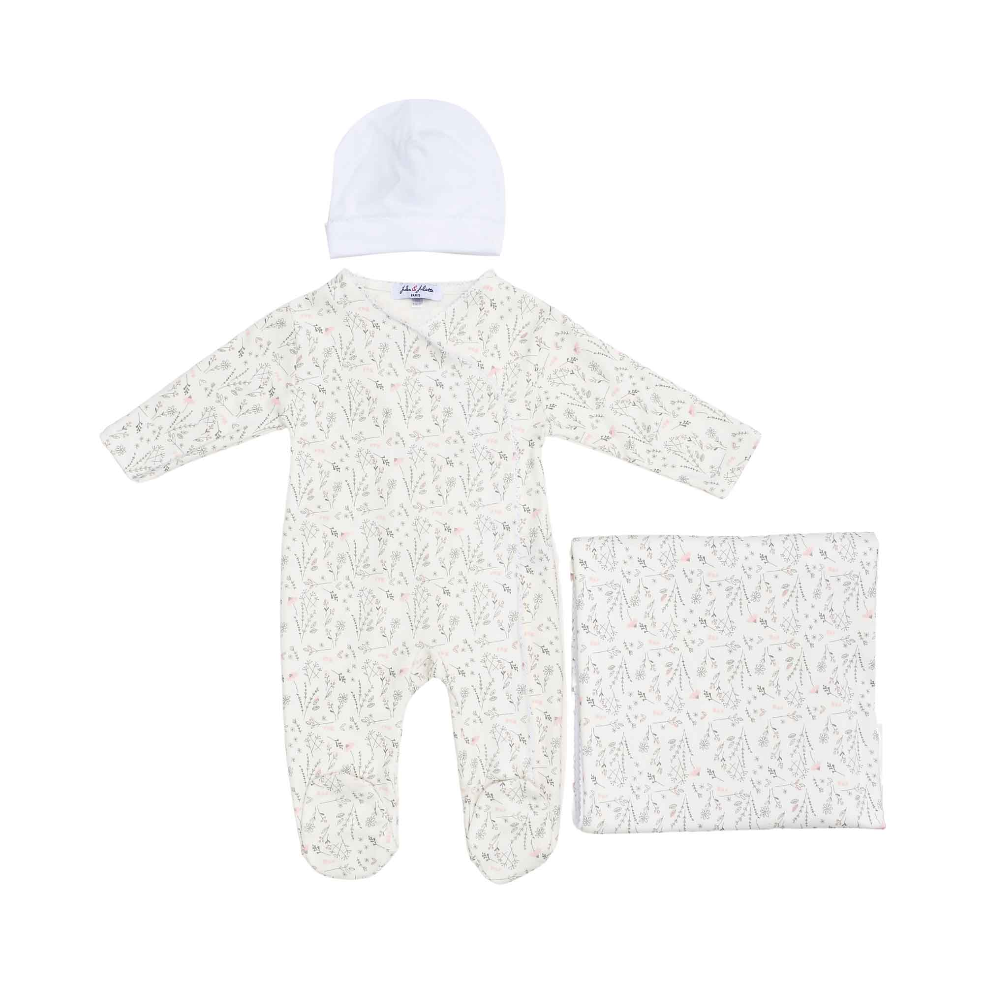 Front view of the Jules & Juliette Paris baby set featuring a wildflower print footed sleepsuit, a white beanie, and a folded matching blanket.