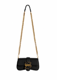 Front view of Just Cavalli women's black leather mini chain shoulder bag with signature gold-tone snake buckle and long chain strap