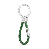 Saint Honore keyring with a silver-toned circular ring, a silver-toned branded disc, and a green braided leather loop.