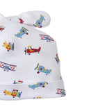 White baby beanie with knotted ears, featuring a multicolor airplane pattern in red, blue, and yellow.