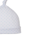 White baby beanie with an allover light blue star pattern, a knotted top, and a folded cuff.