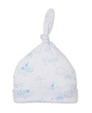 White baby beanie with knotted top and folded brim, featuring a light blue print of sleeping clouds, suns, and stars.