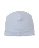 Light blue knit baby beanie with a white scalloped trim along the bottom edge and a small white and light blue embroidered bu