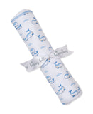 Rolled white blanket with blue whale and wave print, blue stitched edge. Secured with a white ribbon printed 'Kissy Kissy'.
