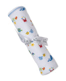 White blanket rolled up, with multicolor sea creature print and blue trim. Tied with a white 'kissy kissy' ribbon.