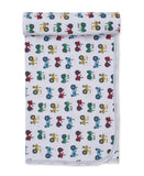 White baby blanket with a repeating pattern of red, blue, green, and yellow tractors, folded at the top.