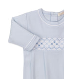 Light blue sleepsuit with white trim on neck and cuffs. White smocked chest panel features light blue diamond embroidery with