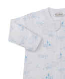 White sleepsuit with light blue celestial print of stars, clouds, suns, and moons. Features long sleeves and a front zipper.