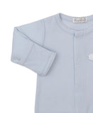 Light blue sleepsuit with white scalloped trim on the neckline, front opening, and sleeve cuffs, featuring a white embroidere