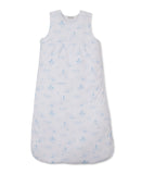 Light blue baby nest with white background and a pattern of moons, stars, clouds, suns, and castles.
