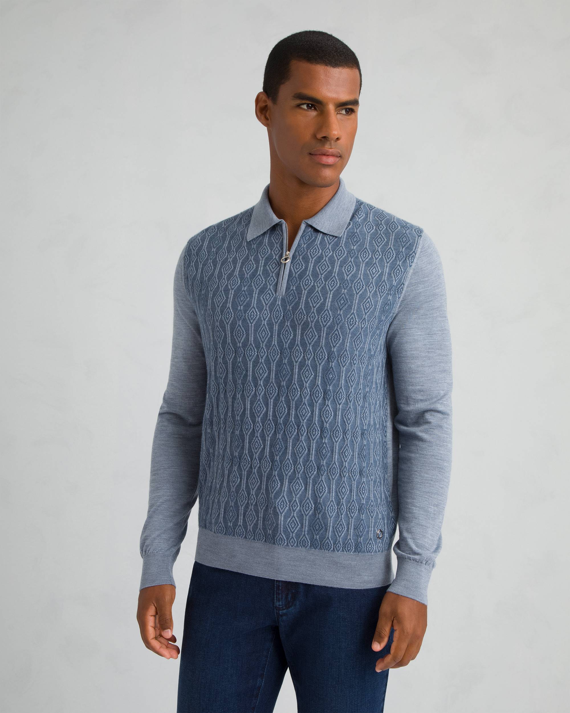Light blue long-sleeved men's polo sweater with a patterned front panel and quarter-zip placket.