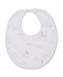 White baby bib with pink scalloped trim. It has a pink celestial pattern of suns, clouds, moons, and stars, and a white snap