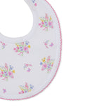 White baby bib with scattered multicolor floral bouquets and butterflies, featuring a pink scalloped trim.