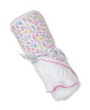 Rolled white terry towel with a floral print in pink, yellow, blue. Features pink scalloped trim and a white "kissy kissy" ri