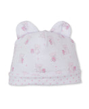 White baby hat with two ears, printed with light pink teddy bears (some holding smaller bears) and tiny pink hearts. Folded h