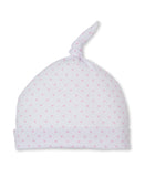 Soft white knit baby hat with small pink heart pattern, a folded brim, and a knotted top.