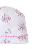 White baby hat with multicolor floral and butterfly print, and a pink scalloped edge.