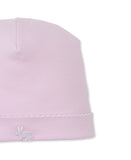 Pink baby beanie with a white scalloped trim along the brim and a small white embroidered bunny.