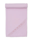Pink knit baby blanket with a rolled top edge and a diagonal band of white smocking and small pink rose embroidery.