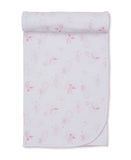 Pink and white baby blanket with an all-over print of suns, moons, clouds, and stars, featuring a pink scalloped edge.