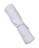 White blanket with pink sun, cloud, and star pattern, pink scalloped trim, and a white ribbon tied around it.