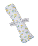 White rolled blanket with yellow lemon and blue floral print, tied with a white 'kissy kissy' ribbon. One end has a ruffled b