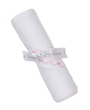 White blanket rolled up, featuring pink smocking with small bows, tied with a white satin ribbon printed with 'kissy'.