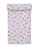 White baby blanket with an all-over pattern of pink floral bows and small colourful flower clusters, finished with a pink sca