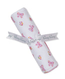 White blanket with multicolor floral bow and flower patterns. Tied with a white 'kissy kissy' ribbon. Pink scalloped trim.