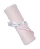Rolled pink knit blanket with a white 'kissy kissy' ribbon, featuring a pink smocked and white ruffled trim.