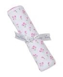 White blanket rolled with pink tulip print, pink scalloped trim, and tied with a gray 'Kissy Kissy' ribbon.