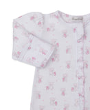 White sleepsuit with a pink teddy bear and heart print. Features a ruffled trim along the front opening and long sleeves with